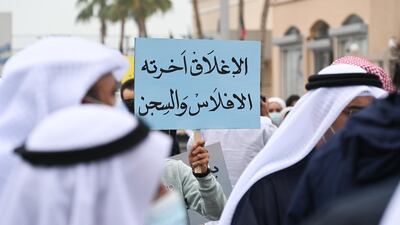 This Kuwaiti demonstrator's placard reads 'Closure ends in bankruptcy and jail'. All businesses, including malls, must close between the hours of 8pm and 5am. EPA