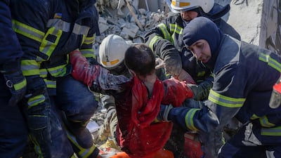 Rescuers carry a Ukrainian soldier saved after 30 hours from debris of the military school hit by Russian rockets in Mykolaiv. AFP
