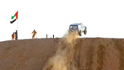 A vehicle from RSG garage in Ajman becomes airborne as it reaches the top of the dune.