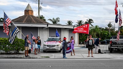 Supporters of former US President Donald Trump wave flags near his Palm Beach residence in Palm Beach following reports of an attempted shooting. AFP