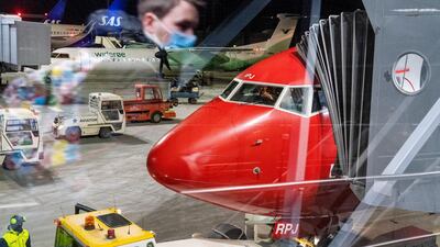 People wait to board a plane from Vaernes airport in Trondheim, Norway. NTB via AP