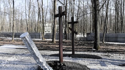 A Russian cluster bomb is seen next to a cross at a war cemetery in Kharkiv, Ukraine. EPA