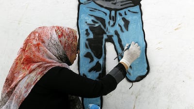 The painting of a boy with an amputated lower leg is the sixth in a series called 'Silent Victims' that Haifa Subay has painted in the rebel-held capital. Yahya Arhab / EPA