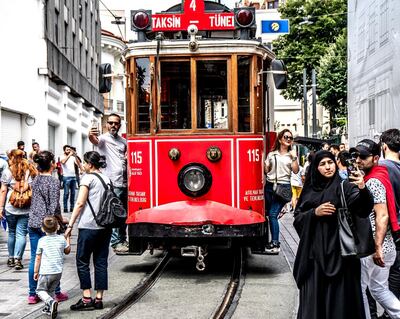 People pose in front of nostalgic tram on Istiklal Street in Istanbul, Turkey, 25 June 2018. EPA/SRDJAN SUKI