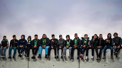 Supporters of Raja Club Athletic sit on top of a wall during a match against Mouloudia Oujda in Casablanca. AFP