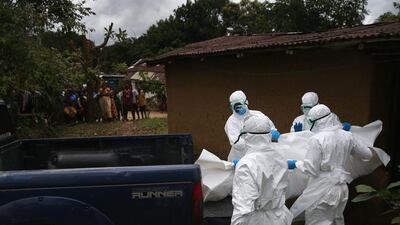 A burial team from the Liberian Red Cross carries the body of an Ebola victim from his home on October 8 near Monrovia, Liberia. John Moore/Getty Images