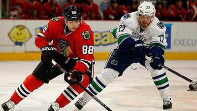Chicago Blackhawks' Patrick Kane edges past Daniel Sedin of Vancouver.