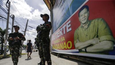 Filipino soldiers stand guard next to an election campaign poster displaying Philippine President Rodrigo Duterte, at a street in Davao City. Recent figures show that from July to September 2016 around 3,500 people have been killed during the anti-drug campaign. Ritchie B Tongo / EPA