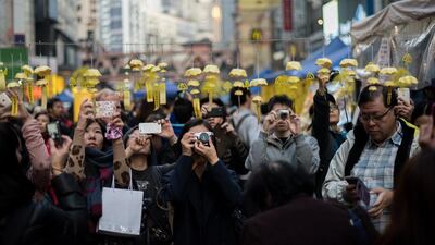 People photograph an installation of paper umbrellas - symbols of the pro-democracy protests in Hong Kong last December. Alex Ogle / AFP