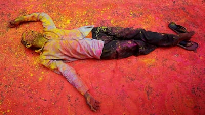 A man smeared in coloured powder takes a rest on a road during a procession for Holi celebrations in Kolkata, India on February 28, 2018. Reuters
