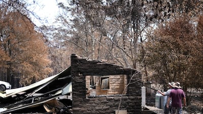 Residents examine damage to their property following bushfires in Budgong National Park. AFP