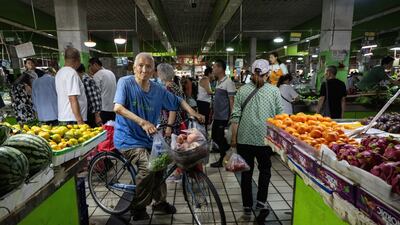 Customers at a wet market in Beijing. Food prices in China fell 1.7 per cent on year while non-food costs rose 0.5 per cent, led by rising costs linked to tourism. Bloomberg