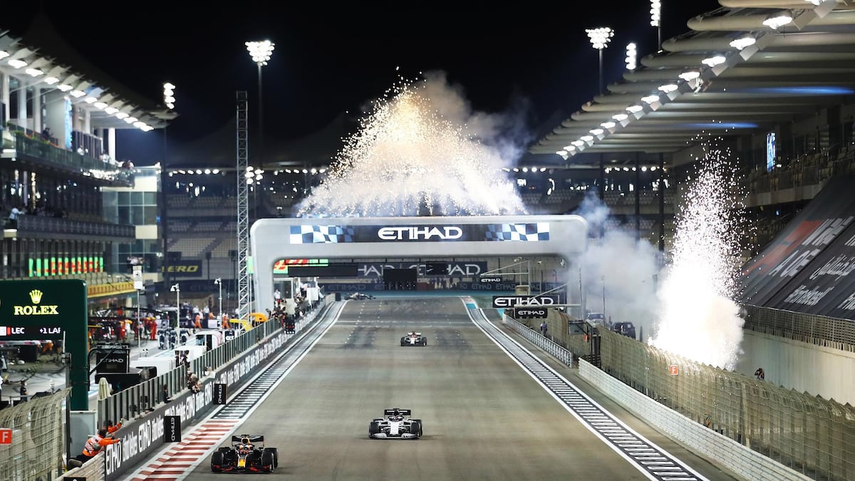 Max Verstappen crosses the finish line at Yas Marina as the Abu Dhabi fireworks erupt.