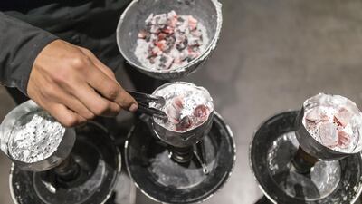 A shisha cafe staff prepares pipes. Such workers have no alternative to facing second-hand smoke risk. Antonie Robertson / The National