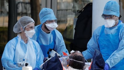 Medical staff move a patient from a special high-speed train to an ambulance during a transfer operation of people infected with Covid-19. REUTERS