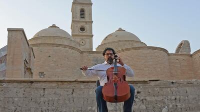 Famed Iraqi maestro and cello player Karim Wasfi performs in front of the Roman Catholic Church of Our Lady of the Hour in Mosul’s war-ravaged Old City on June 29, 2018. Zaid Al Obeidi / AFP