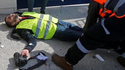 A wounded Palestinian journalist lies on the ground during a protest in Bethlehem to show solidarity with his colleague Muath Amarneh. REUTERS