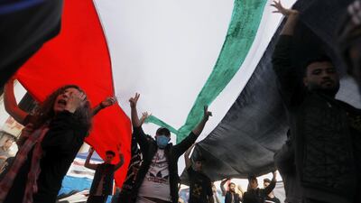 Demonstrators carry huge Iraqi flag during an ongoing anti-government protests. Reuters