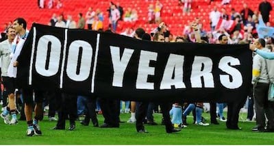 United supporters display a banner in February showing how many years it has been since City won a trophy. Mike Hewitt / Getty Images