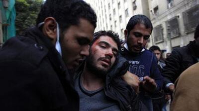 A injured man is evacuated during clashes near Tahrir Square in Cairo on Friday. Khalil Hamra / AP Photo