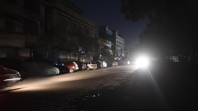 Motorists drive through a residential area during a power blackout in Pakistan's port city of Karachi. AFP
