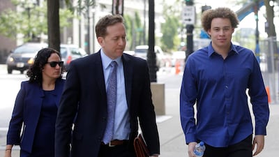 Marcus Hutchins (R), the British cyber security expert accused of creating and selling malware that steals banking passwords, arrives with his lawyers. AFP