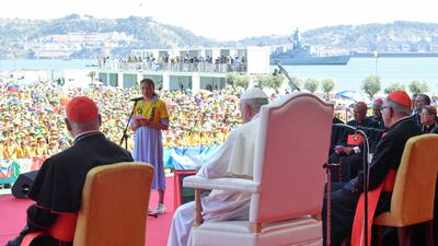 Pope Francis listens as a person speaks on the stage during a meeting with World Youth Day volunteers in Lisbon. Reuters