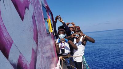 Migrants pose for a photo after being rescued by the Louise Michel. MV Louise Michel via Reuters