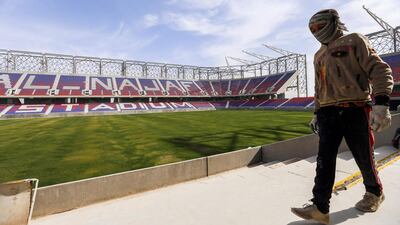 A man walks near the pitch in Najaf International Stadium in Iraq's central shrine city on February 8, 2018. Haidar Hamdani / AFP