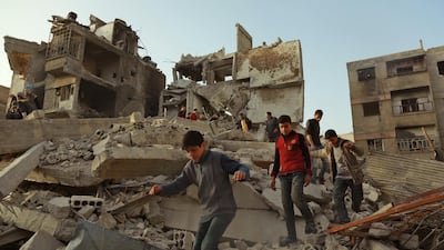 Syrian civilians walk above the rubble of destroyed buildings in the rebel enclave of Eastern Ghouta on March 5, 2018 on the outskirts of Damascus. Hamza Al-Ajweh / AFP