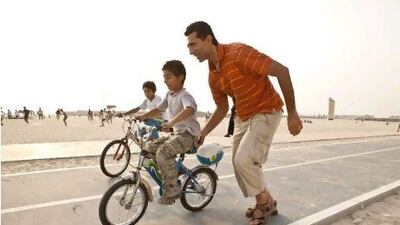 Marcus Abdelsayed teaches his son Anthony how to ride while his brother Peter follows in the background at Jumeirah Open Beach.