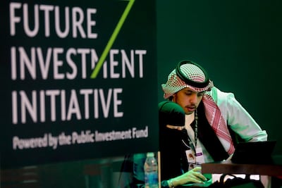 Saudi employees print badges of participants of the Future Investment Initiative in Riyadh, Saudi Arabia. AP