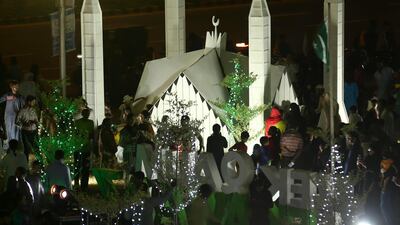 People visiting illuminated model representations of the Faisal Mosque ahead of Pakistan Independence Day celebrations in Karachi. EPA