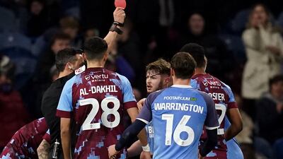 Fleetwood Town's Cian Hayes, centre, is shown a red card by referee Dean Whitestone. PA