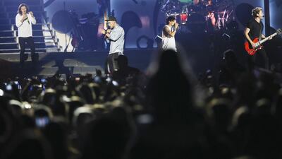 One Direction perform for screaming fans at The Sevens Stadium in Dubai. From left, Harry Styles, Liam Payne, Louis Tomlinson and Niall Horan kept their loyal legions yelling for more, despite the absence of Zayn Malik, who has left the group. Sarah Dea / The National
