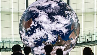 Reporters observe the Geo-Cosmos, the world’s first spherical display made using organic electroluminescent panels showing a high-resolution model of the Earth, during a media preview in Tokyo. AFP