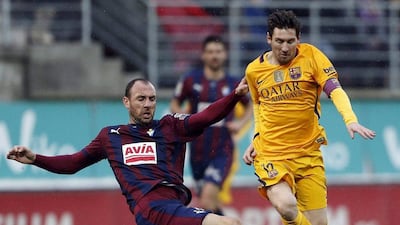 Lionel Messi, right, fights for the ball with Eibar defender Ivan Ramis. Javier Etxezarreta / EPA