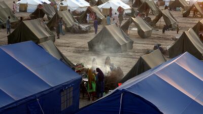 People displaced by record floods prepare tea at a temporary camp set up by the UN Refugee Agency in Sukkur, Pakistan. AP