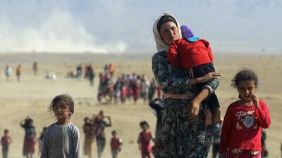 Displaced people from the minority Yazidi sect, fleeing violence from forces loyal to the Islamic State in Sinjar town, walk towards the Syrian border on the outskirts of Sinjar mountain near the Syrian border town of Elierbeh of Al-Hasakah Governorate in this August 11, 2014. Rodi Said / Reuters