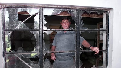 Zimbabwean farmer Paul Retzlaff stands on April 12, 2000 in front of a broken window at his home in Arcturus, Gormonzi district, 30 km east of Harare, a day after clashes broke out at his farm when drunken would-be squatters invaded the property before being repelled by black farm workers. Retzlaff said shots had been fired by the invaders, including a leading veteran of the war against white rule in the 1970s. The couple was saved after black farm workers from neighbouring farms responded to a call for help over ham radio. His wife Liz said the invaders were shouting that they had president Robert Mugabe's permission to invade the property. Alexander Joe / AFP