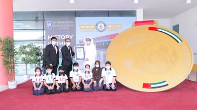 Staff and pupils at International Indian School Abu Dhabi with their record-breaking medal. International Indian School Abu Dhabi