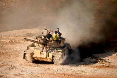 Syrian rebel fighters ride a tank in Daraa, southwestern Syria, on June 23, 2018. AFP / Mohamad Abazeed
