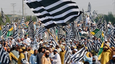 Supporters of Jamiat Ulema-i-Islam-Fazl wave party flags in Peshawar on October 27, 2019 as they begin their march on the Pakistani capital. AFP