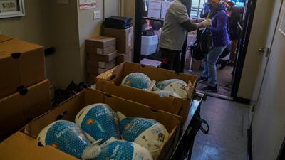 Volunteer Sean Armstrong hands turkeys to volunteer Nina Norwood at Harlem's Food Bank For New York City, a community kitchen and food pantry. AP Photo