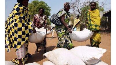 Southern Sudanese women carry sacks of food distributions by the World Food Programme in Juba, southern Sudan, yesterday.
