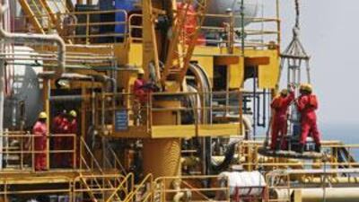 Crew members arrive at an oil platform at the Mubarek field off the coast of Sharjah. A reader argues against the premise of the Peak Oil theory on the grounds that reserves are less than one-third depleted.