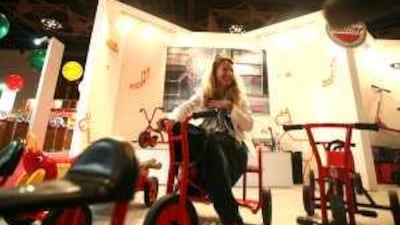 Deborah Carter tries out the Winther tricycle at the Middle East Toy Fair at the Dubai International Convention Centre.