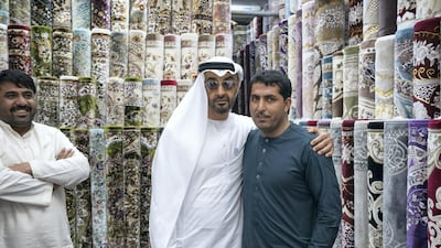 Sheikh Mohammed stands for a photograph with staff at Al Safa Carpet shop, in the carpet market of the Mina Zayed Port. Ryan Carter for the Crown Prince Court - Abu Dhabi