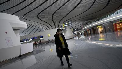 A woman wearing a face mask walks at the Beijing Daxing International Airport, as the country is hit by an outbreak of the novel coronavirus, in Beijing, China February 20, 2020. REUTERS/Tingshu Wang