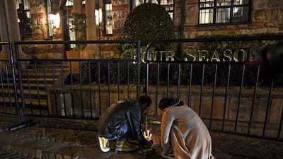 People light candles in front the hotel where Hawkins died. AFP